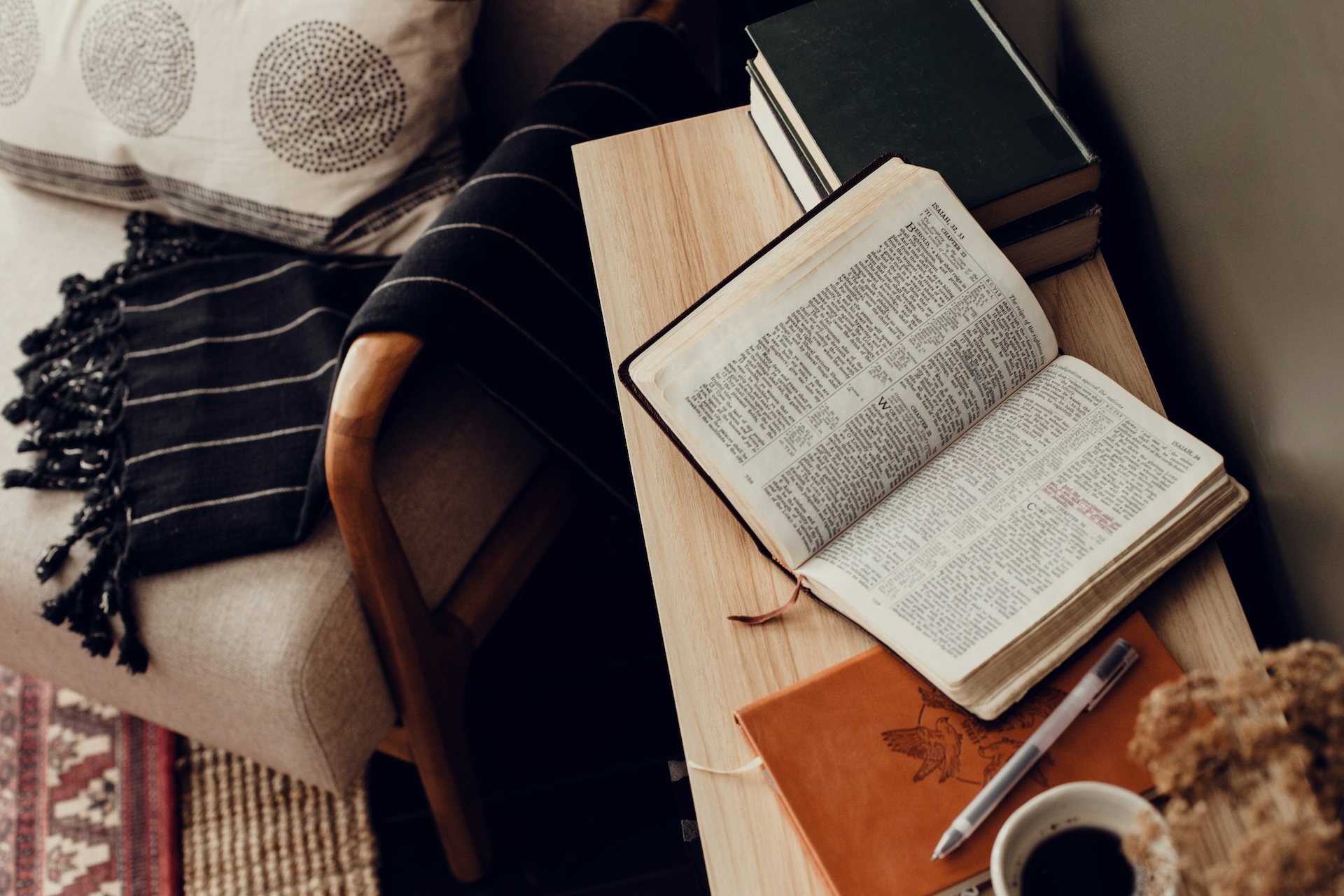 Bible opened to the book of Isaiah on a desk with a journal